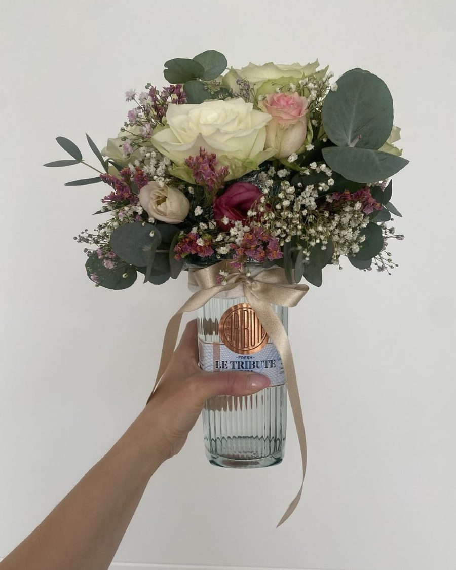 Champagnerflasche Colligny mit einem Strauss aus cremefarbenen und rosa Rosen, Schleierkraut und Eukalyptus